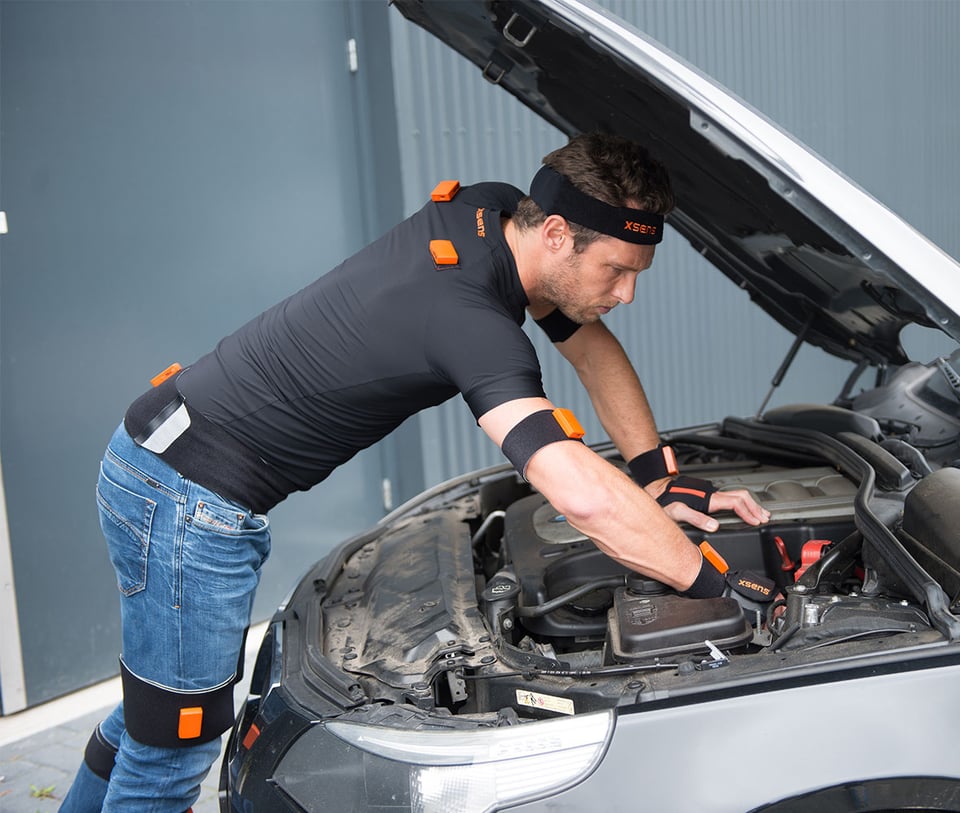 Man with Xsesn sensors looking under car bonnet