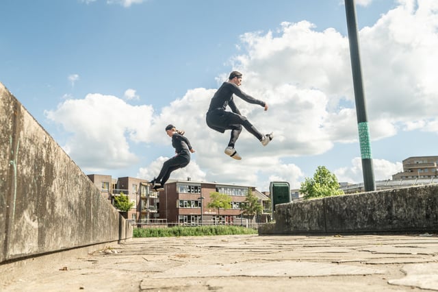 Mocap free runners jumping over pavement 